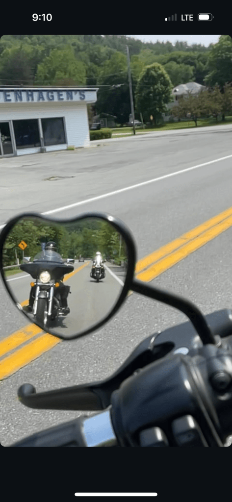 Visual: Motorcycle heart shaped mirror, reflects other two riders behind.